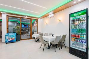 a restaurant with a table and chairs and a drink refrigerator at Apart-Hotel President 2 in Ulcinj