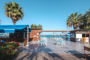 ein Restaurant mit Stühlen und dem Meer im Hintergrund in der Unterkunft Risus Beach Resort Hotel in Kusadası