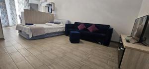 a living room with a bed and a couch at Azizi Apartments Beach & Spa Resort piscina incalzita in Mamaia Nord