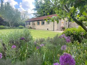 a garden in front of a stone house at The Old Piggery - tranquil garden guest cottage in Hail Weston