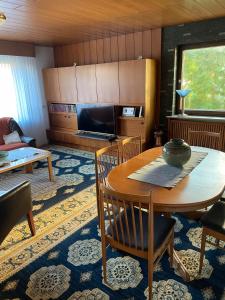 a living room with a table and a tv at Traumhaftes Wohnen beim Badesee in Dechsendorf