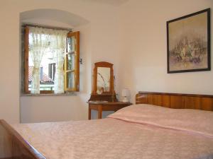een slaapkamer met een bed, een spiegel en een raam bij Apartments Camellia & Magnolia in Volosko
