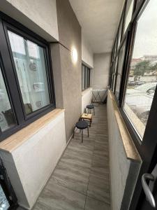 Un pasillo de un edificio con dos sillas y ventanas. en Studio Chic, en Craiova