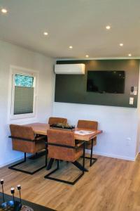 a dining room with a table and chairs and a tv at Ferienhaus Noa für 5 Personen, angeln ,familienfreundlich in Twist