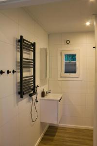 a white bathroom with a sink and a window at Ferienhaus Noa für 5 Personen, angeln ,familienfreundlich in Twist