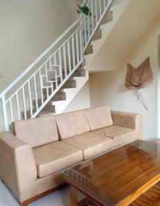 a living room with a couch and a staircase at Villa Omah Singgah Gunung Andong in Magelang