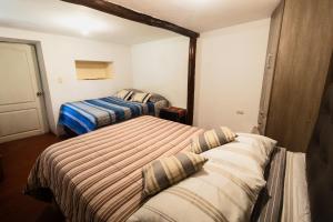 a bedroom with two beds in a room at Pinkuylluna Lodge in Ollantaytambo
