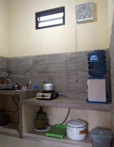 a kitchen with a counter top with a sink at Villa Omah Singgah Gunung Andong in Magelang