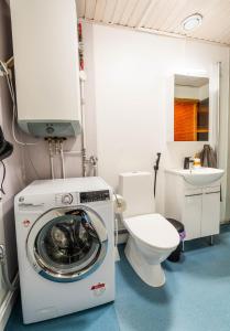 a bathroom with a washing machine and a toilet at Cozy Ranua Koivutie townhouse with sauna & terrace in Ranua