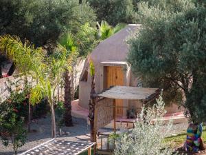 a small house in a garden with trees at Villa Roswell with Pool Privatisation in Heddad
