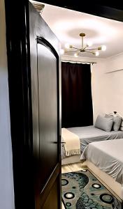 a small bedroom with a bed and a refrigerator at Spacious 2BR Apt 2BA Gated Community in Sheikh Zayed