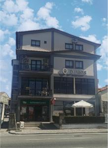 ein hohes Gebäude mit einem Restaurant davor in der Unterkunft Dom Dinis in Trancoso
