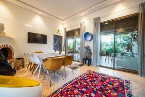 a dining room with a table and chairs and a fireplace at Villa Roswell with Pool Privatisation in Heddad