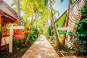 莱特鲁瓦西莱Hotel Bambou的棕榈树环绕的建筑物前的人行道