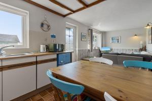 a kitchen and living room with a wooden table and chairs at No 1 Cottage in Brixham