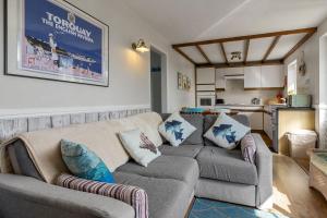 a living room with a couch and a kitchen at No 1 Cottage in Brixham +26 photos
