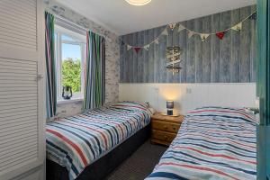 a bedroom with two beds and a window at No 1 Cottage in Brixham