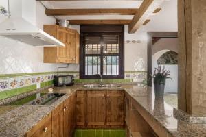 a kitchen with wooden cabinets and a sink at Casa rural con piscina compartida y WIFI in Roche