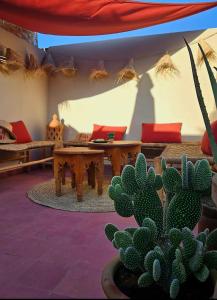 マラケシュにあるRiad Awel Oasis Privée au coeur de la Medinaのテーブルと椅子、サボテン付きの部屋 +15枚の写真