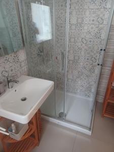 une salle de bain avec douche et lavabo dans l'établissement Tamarin De Mar, à Alghero
