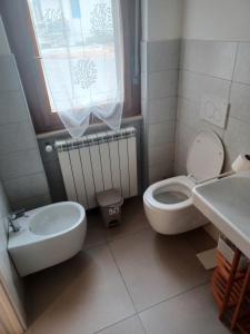 une salle de bains avec toilettes et lavabo dans l'établissement Tamarin De Mar, à Alghero