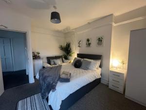 Un dormitorio con una cama grande con sábanas y almohadas blancas. en Top Floor Suite - Cedar House, en Hereford