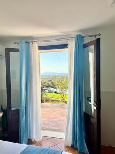 a bedroom with a sliding glass door with a view at Villa Demirà - Chic Panoramic Rooms Marsala in Marsala