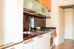 a kitchen with white cabinets and a sink at La casa di Leonardo in Civitanova Marche +13 photos