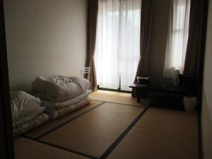 a room with a bed in front of a window at Funayado Akitaya in Kamakura