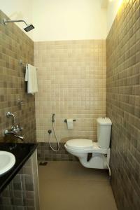 a bathroom with a toilet and a sink at Dr Nisha's Vedic Remedies in Trivandrum