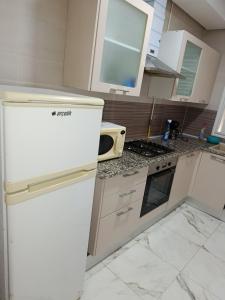 une cuisine avec des armoires blanches et un réfrigérateur blanc dans l'établissement Mira house, à Ariana
