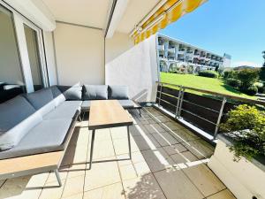 a living room with a couch and a table on a balcony at JJ Living - Bergzeit 160 in Scheidegg