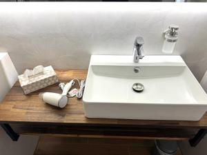 a white bathroom sink on a wooden table at JJ Living - Bergzeit 160 in Scheidegg