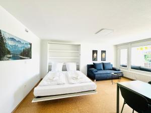 a white bedroom with a bed and a couch at JJ Living - Bergzeit 160 in Scheidegg +34 photos