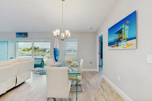 a dining room and living room with a table and chairs at Into the Blue in Cape Coral Hospital Heliport