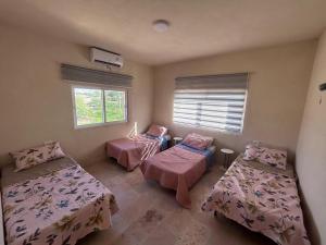 una habitación con tres camas y una ventana en Nay's Chalet, en Shūnat Nimrīn