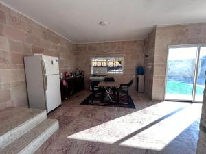 Una cocina con un refrigerador blanco y una mesa. en Nay's Chalet, en Shūnat Nimrīn