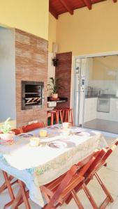 a dining room table with chairs and a fireplace at Casa entre a praia e a lagoa pequena in Florianópolis