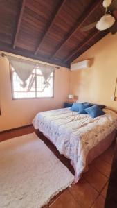 a bedroom with a large bed with blue pillows at Casa entre a praia e a lagoa pequena in Florianópolis
