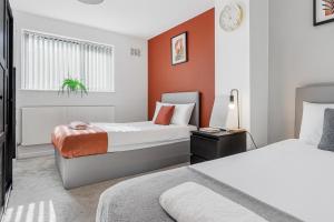 two beds in a room with orange walls at Highland House in Birmingham