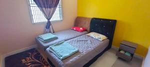 a small bed in a room with a window at Homestay Hajah Jamilah Sungai Tiram 04 in Ulu Tiram +2 photos