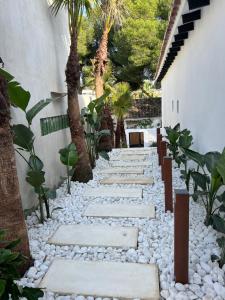 ein Gehweg mit Felsen und Palmen in einem Hof in der Unterkunft DreamHomesByMaria next to puerto banus in Marbella