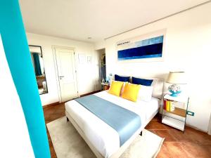 a bedroom with a large bed with yellow and blue pillows at Villa Demirà - Sky&Pool - Rooms in Marsala +53 photos