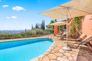a villa with a swimming pool and an umbrella at Villa Nefeli in Nisakion
