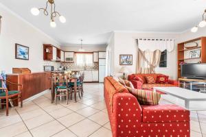 a living room with red couches and a kitchen at Villa Nefeli in Nisakion