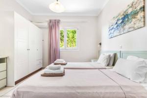 a bedroom with two beds and a window at Villa Nefeli in Nisakion +21 photos