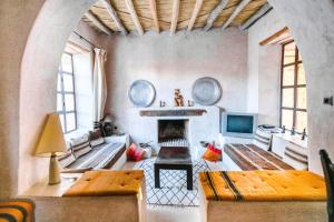 a living room with a fireplace and a couch at Villa Agouni - Charming villa with cook service in Essaouira