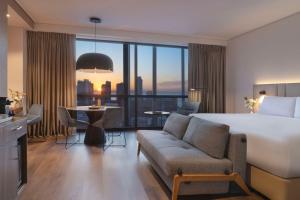 una camera d'albergo con un letto e un soggiorno di NH Iquique Pacifico a Iquique