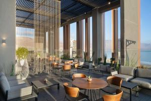 una hall con tavoli, sedie e l'oceano di NH Iquique Pacifico a Iquique