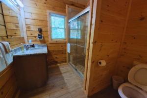 a log cabin bathroom with a shower and a toilet at Misty Mountain View - 2 bedroom cabin in Glade +19 photos